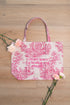 Primo piano del ricamo Sankalpa su zafu bag per accompagnare il tuo cambiamento, in toile de Jouy rosa, con fiori freschi intorno.